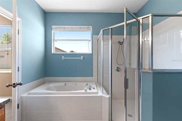 full bathroom with a healthy amount of sunlight, vanity, a stall shower, and a garden tub