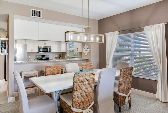 425 150th Ave Unit 2301, Madeira Beach, FL 33708 - dining room featuring light carpet
