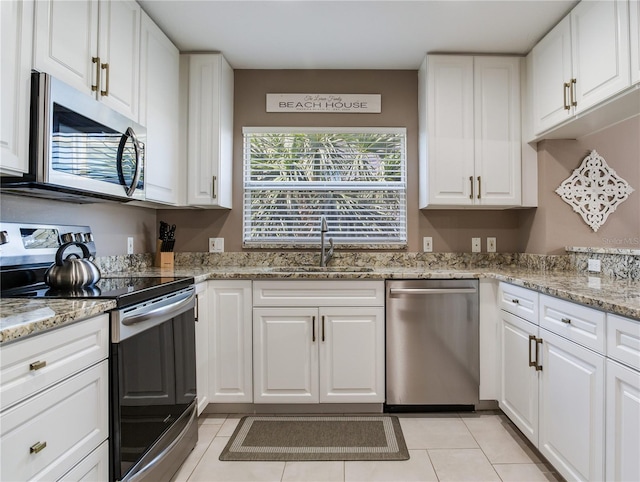 425 150th Ave Unit 2301, Madeira Beach, FL 33708 - kitchen with stainless steel appliances, white cabinetry, light tile patterned floors, and light stone countertops