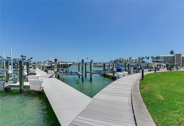 425 150th Ave Unit 2301, Madeira Beach, FL 33708 - dock featuring boat lift, a water view, and a lawn