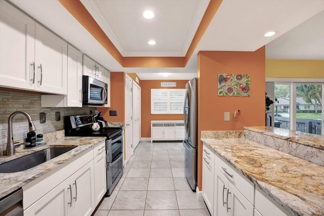 50 Balsam Dr, Oldsmar, FL 34677 - kitchen with appliances with stainless steel finishes, a sink, decorative backsplash, white cabinetry, and light stone countertops