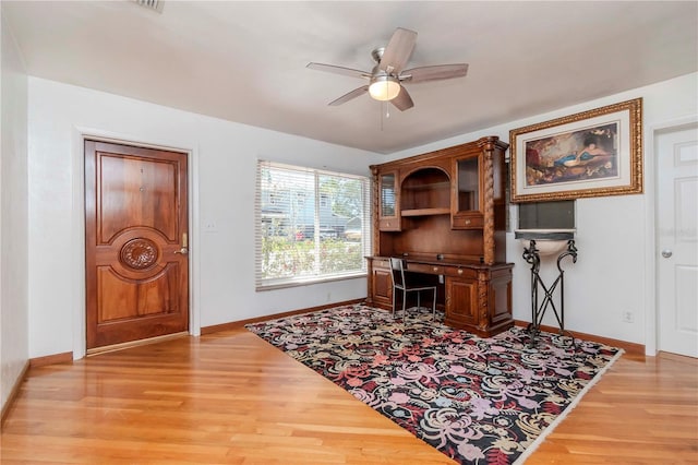 office with baseboards, a ceiling fan, and light wood-style flooring