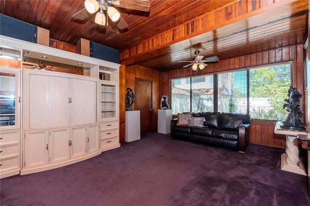 living area with dark colored carpet, ceiling fan, and wooden walls
