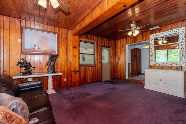 living room with wooden walls, a ceiling fan, visible vents, wood ceiling, and carpet floors