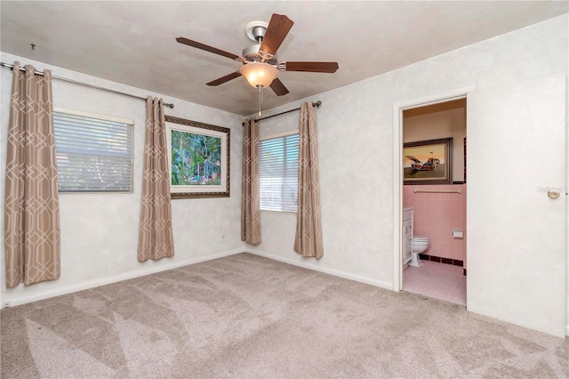empty room with a ceiling fan and carpet flooring