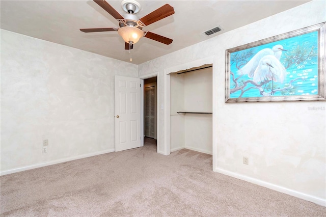 unfurnished bedroom with carpet flooring, visible vents, a closet, baseboards, and a ceiling fan