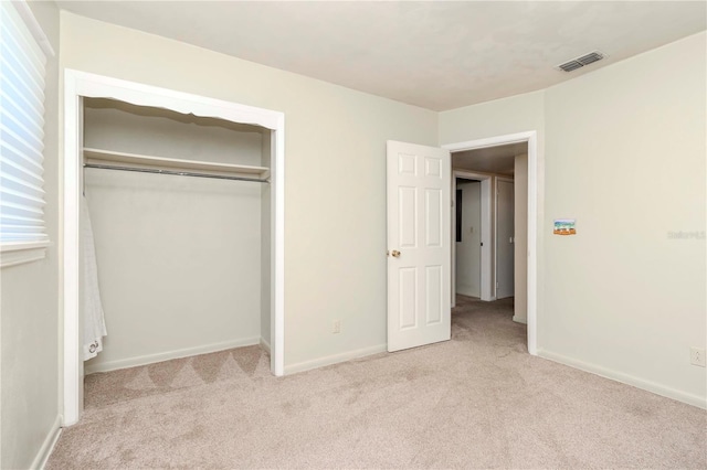unfurnished bedroom featuring baseboards, visible vents, a closet, and carpet flooring