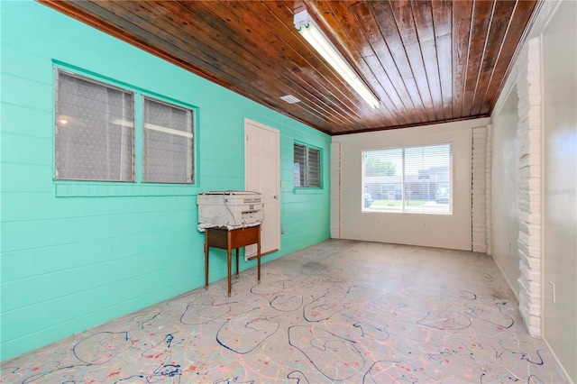 spare room with concrete flooring and wood ceiling