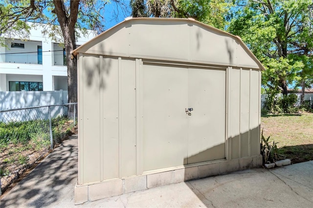 view of shed featuring fence