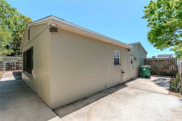 view of home's exterior with fence and a patio area