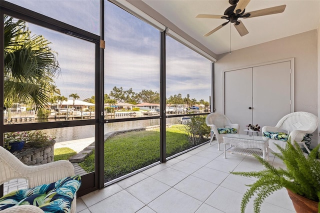 sunroom / solarium featuring a ceiling fan and a water view