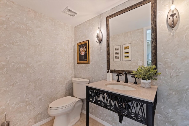 half bathroom with toilet, tile patterned flooring, visible vents, and vanity