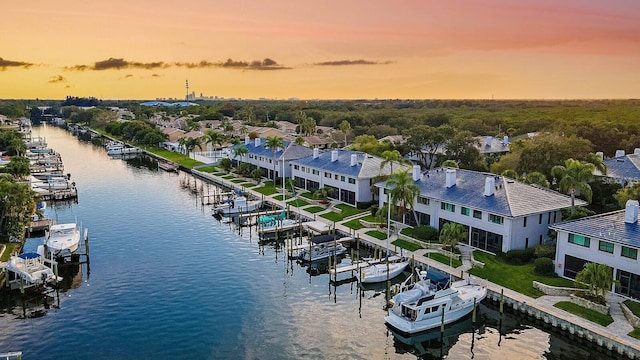 aerial view at dusk featuring a water view
