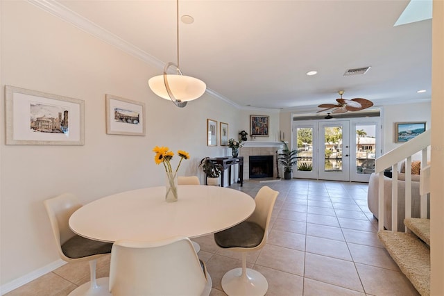 dining space with stairs, light tile patterned floors, a fireplace, visible vents, and crown molding