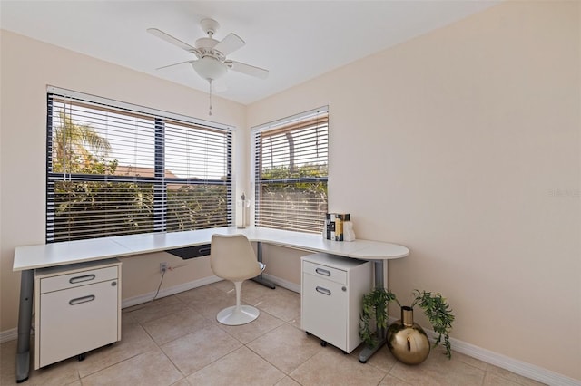unfurnished office featuring baseboards, light tile patterned floors, a ceiling fan, and built in study area
