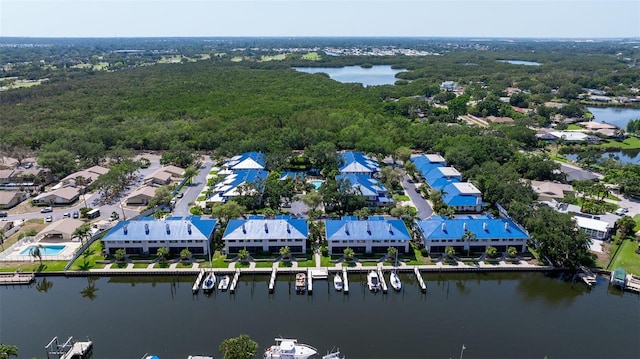 bird's eye view with a water view, a view of trees, and a residential view