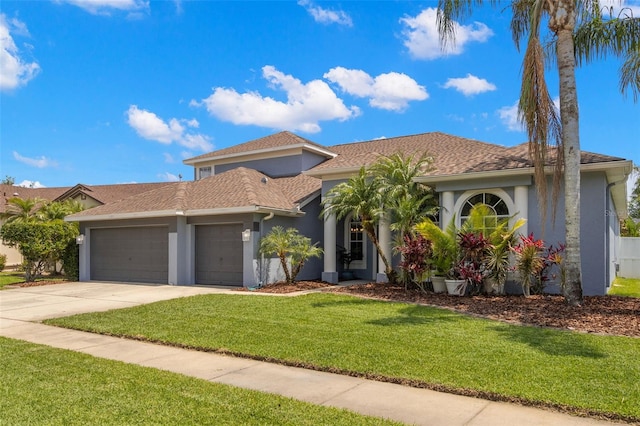 mediterranean / spanish home featuring driveway, stucco siding, a front lawn, and a garage