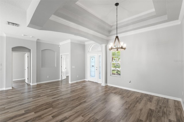 interior space with a raised ceiling, visible vents, dark wood-style floors, arched walkways, and an inviting chandelier