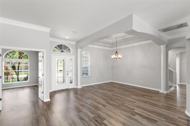 foyer with decorative columns, visible vents, and arched walkways