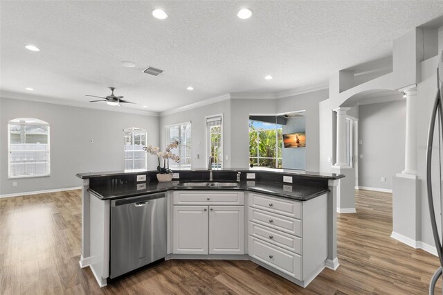 kitchen with a sink, a textured ceiling, dishwasher, and decorative columns