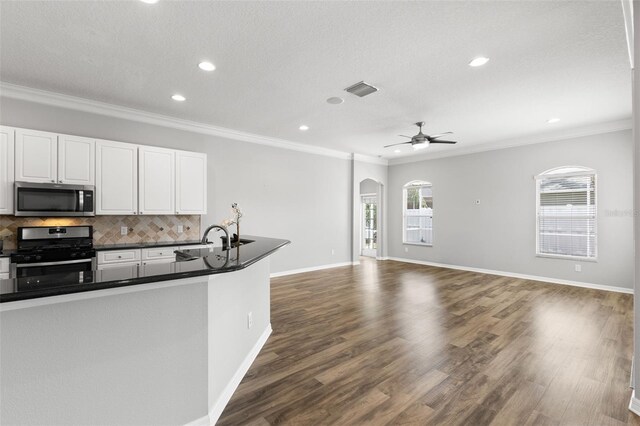 kitchen featuring a wealth of natural light, stainless steel appliances, dark countertops, and a sink