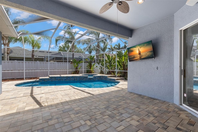 view of pool with a pool with connected hot tub, a patio area, ceiling fan, glass enclosure, and fence