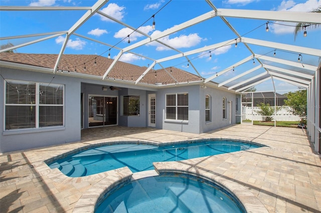 rear view of house featuring a shingled roof, stucco siding, and a patio area