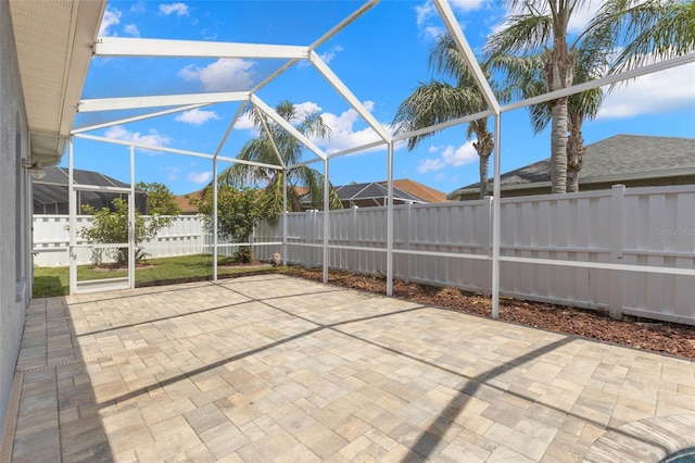view of patio featuring glass enclosure and a fenced backyard