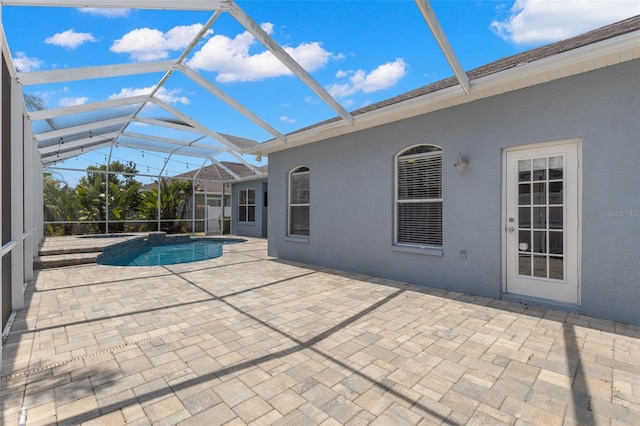 outdoor pool featuring a patio and glass enclosure