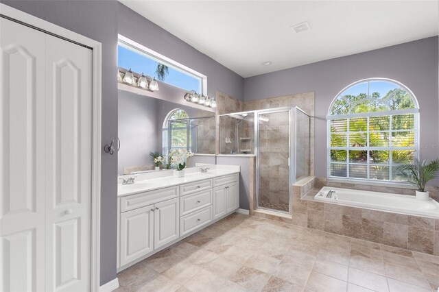 full bath featuring a sink, a bath, double vanity, and a shower stall