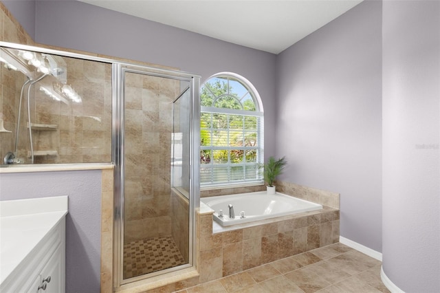bathroom featuring a shower stall, baseboards, tile patterned floors, a garden tub, and vanity