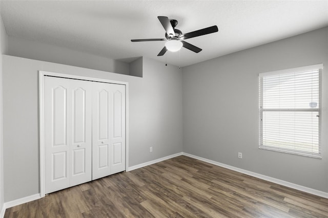 unfurnished bedroom with wood finished floors, ceiling fan, a closet, and baseboards