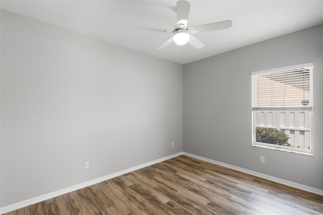 empty room featuring baseboards, wood finished floors, and a ceiling fan