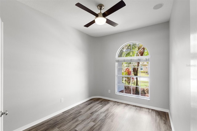 unfurnished room with wood finished floors, ceiling fan, and baseboards
