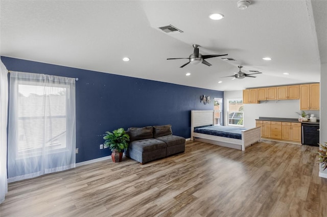 bedroom with visible vents, baseboards, vaulted ceiling, and light wood-style floors
