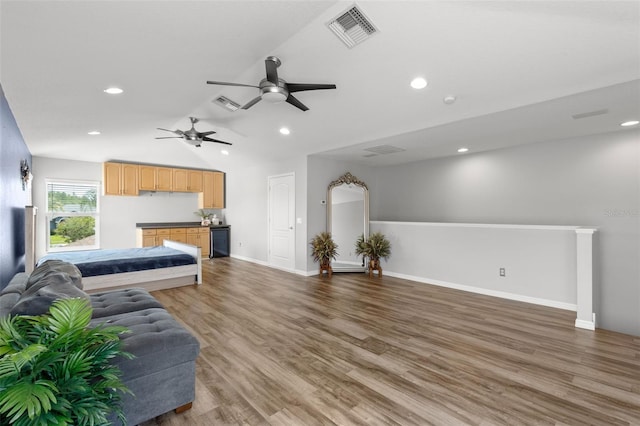 living area featuring baseboards, visible vents, wood finished floors, and lofted ceiling