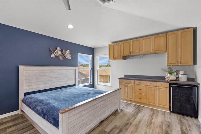bedroom with baseboards, light wood-type flooring, recessed lighting, and wine cooler