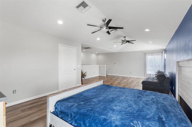 bedroom featuring lofted ceiling, wood finished floors, visible vents, and baseboards