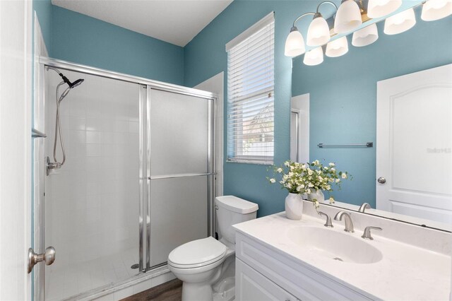 full bathroom with a stall shower, toilet, and vanity