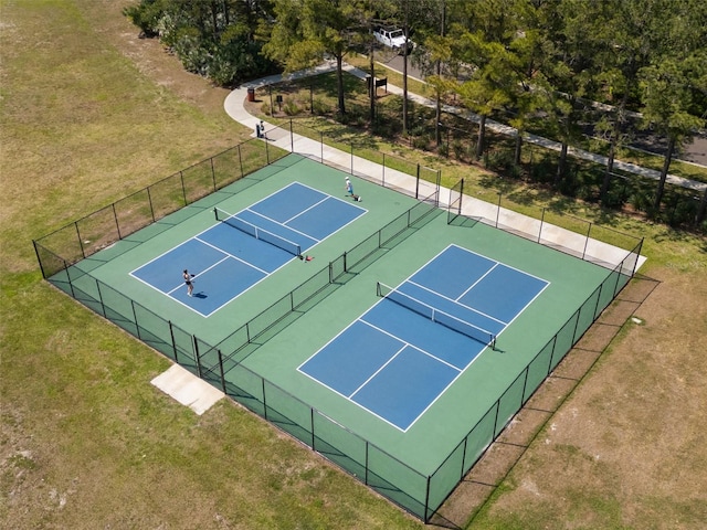 view of sport court featuring fence and a lawn