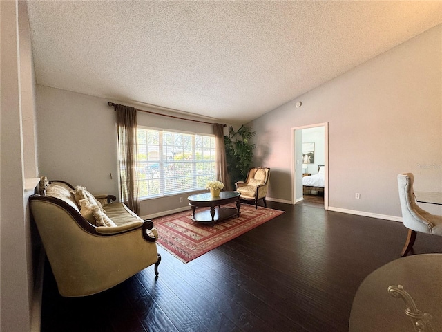 living room with a textured ceiling, lofted ceiling, wood finished floors, and baseboards