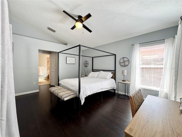 bedroom with a textured ceiling, visible vents, wood finished floors, and baseboards