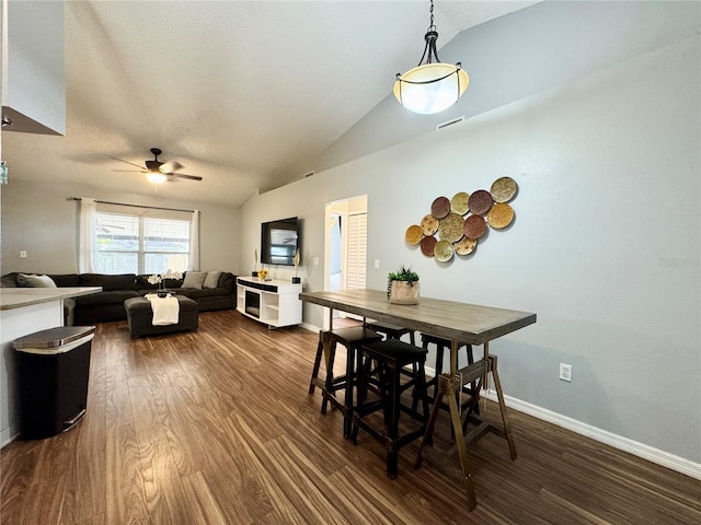 dining room with vaulted ceiling, ceiling fan, dark wood finished floors, and baseboards
