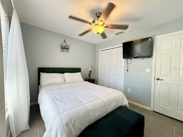 tiled bedroom with baseboards, visible vents, a ceiling fan, and a closet