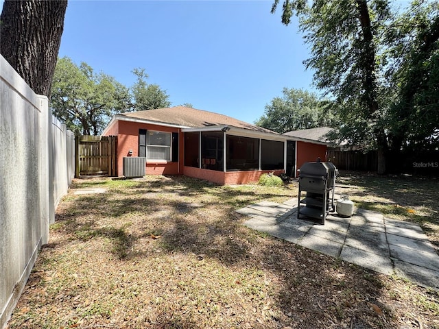 rear view of property with a fenced backyard, cooling unit, a sunroom, and a patio area