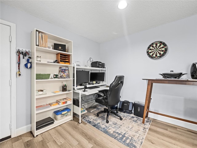 home office featuring a textured ceiling, baseboards, and wood finished floors