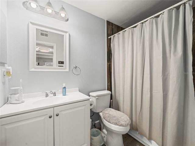 full bath with vanity, toilet, curtained shower, and visible vents