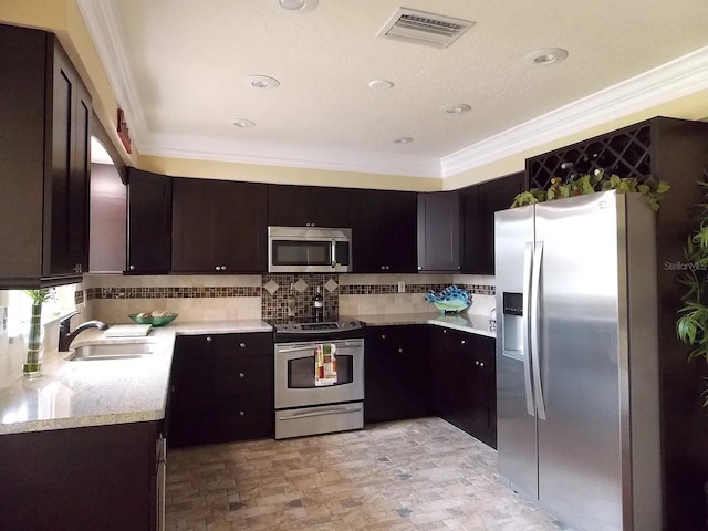 3065 Merrill Ave, Clearwater, FL 33759 - kitchen featuring stainless steel appliances, ornamental molding, a sink, dark brown cabinetry, and tasteful backsplash