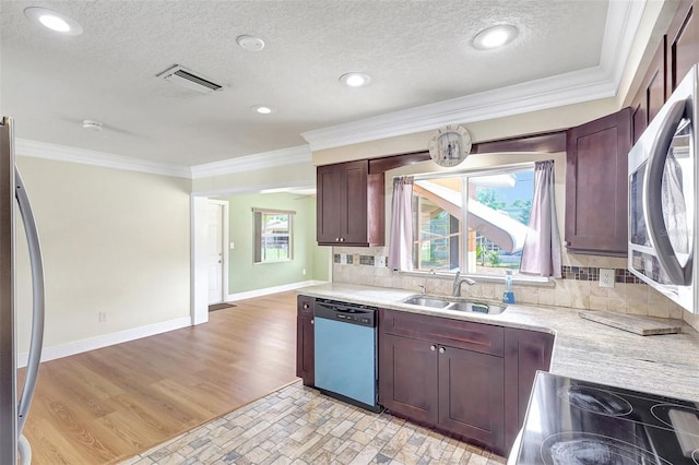 3065 Merrill Ave, Clearwater, FL 33759 - kitchen with stainless steel appliances, a sink, ornamental molding, tasteful backsplash, and light wood finished floors