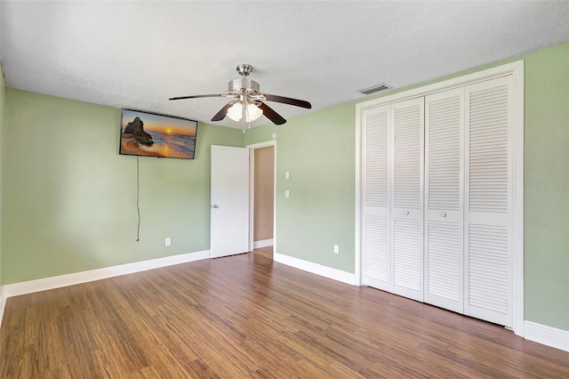 3065 Merrill Ave, Clearwater, FL 33759 - unfurnished bedroom featuring wood finished floors, baseboards, a closet, and ceiling fan